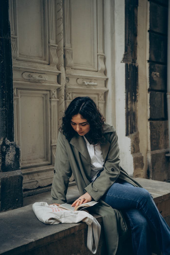 Young Woman Reading a Book in Front of an Old Carved Door